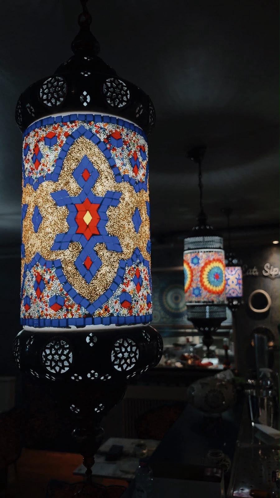 Interieur van Mosaic Amsterdam, sfeerbeeld 6 met mozaïeklampen, donkerblauwe wanden en gouden accenten